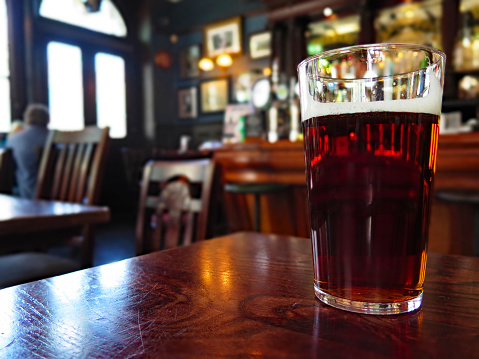 A glass of beer in a London pub with blurred background
