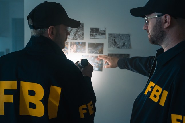 FBI agents at work exploring photos on the wall during investigation